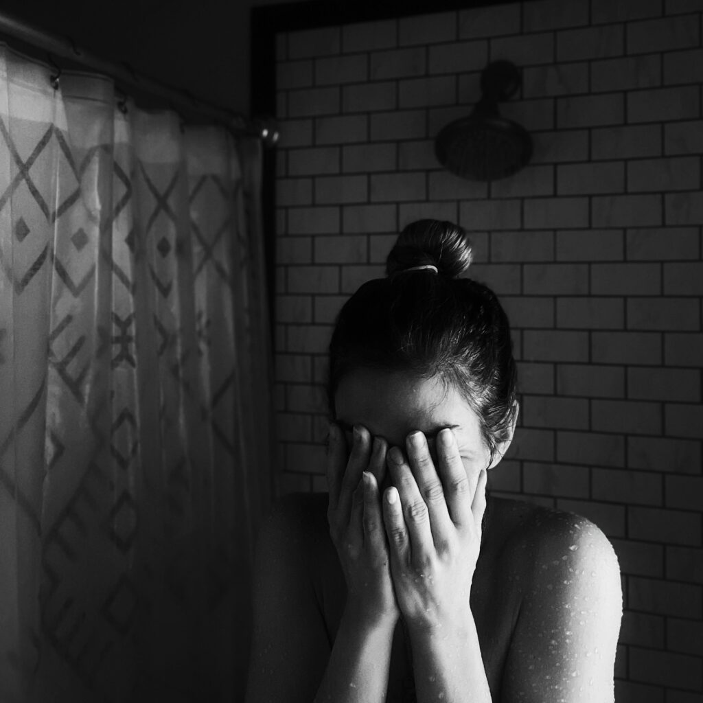 Vrouw met handen voor haar ogen door langdurige stress symptomen en wanhoop
